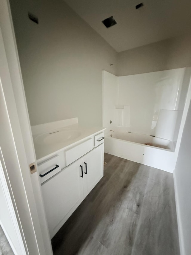 bathroom with shower / tub combination, wood finished floors, and vanity