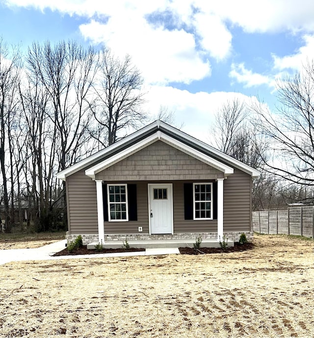 view of front of home with fence and a porch