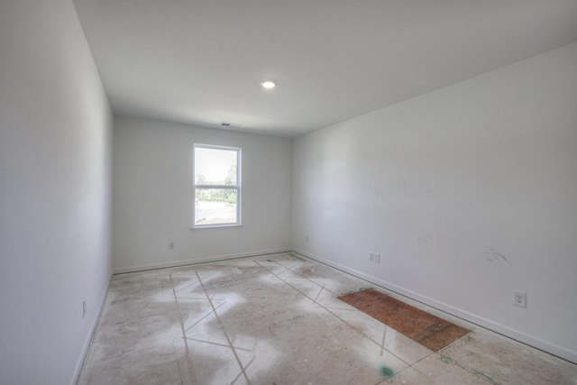 unfurnished room with baseboards