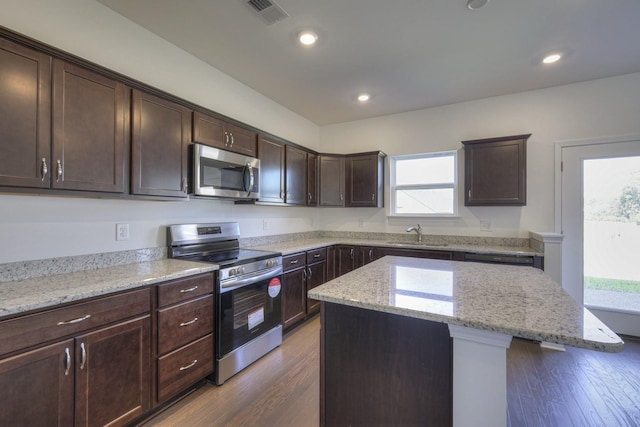 kitchen featuring dark brown cabinetry, visible vents, dark wood finished floors, appliances with stainless steel finishes, and a sink