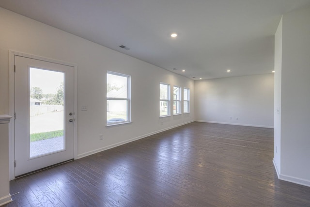 empty room with recessed lighting, dark wood finished floors, visible vents, and baseboards