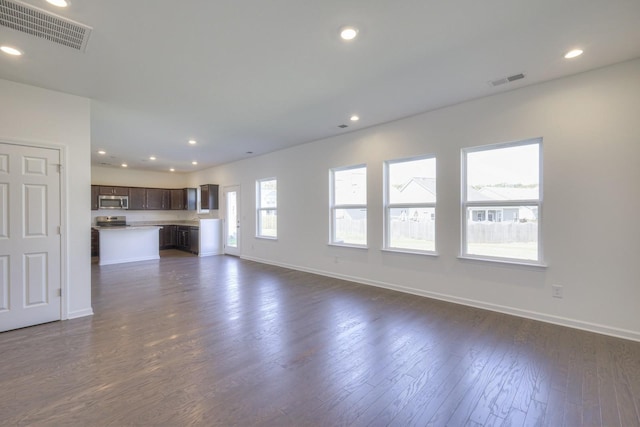 unfurnished living room featuring dark wood-style floors, recessed lighting, visible vents, and baseboards