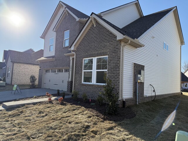 view of front of house featuring concrete driveway, brick siding, and an attached garage