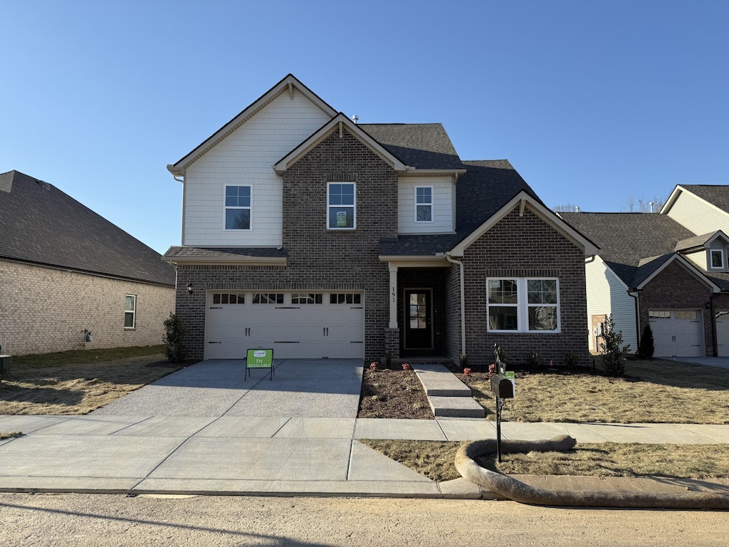 view of front of house featuring a garage, concrete driveway, and brick siding