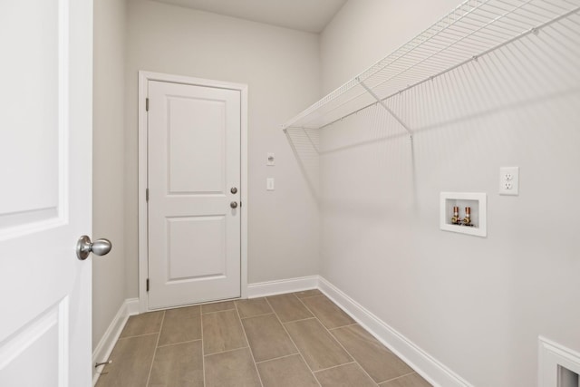 clothes washing area with hookup for a washing machine, laundry area, and baseboards