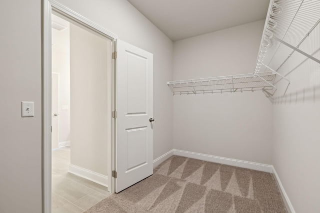 walk in closet featuring light colored carpet