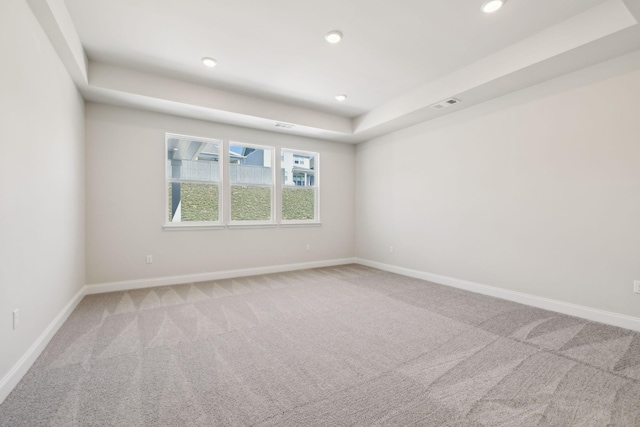 carpeted spare room featuring recessed lighting, visible vents, and baseboards