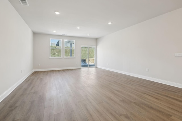 empty room with visible vents, baseboards, wood finished floors, and recessed lighting