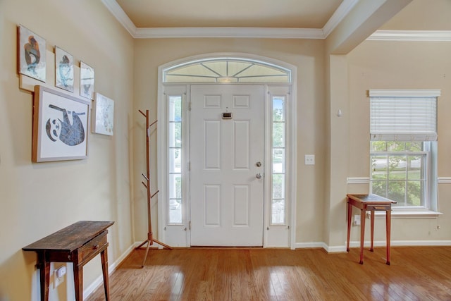 entrance foyer with hardwood / wood-style flooring, baseboards, and crown molding