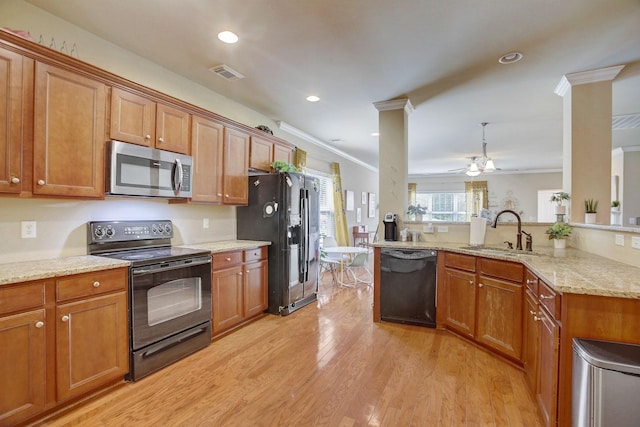 kitchen featuring brown cabinetry, visible vents, a sink, and black appliances
