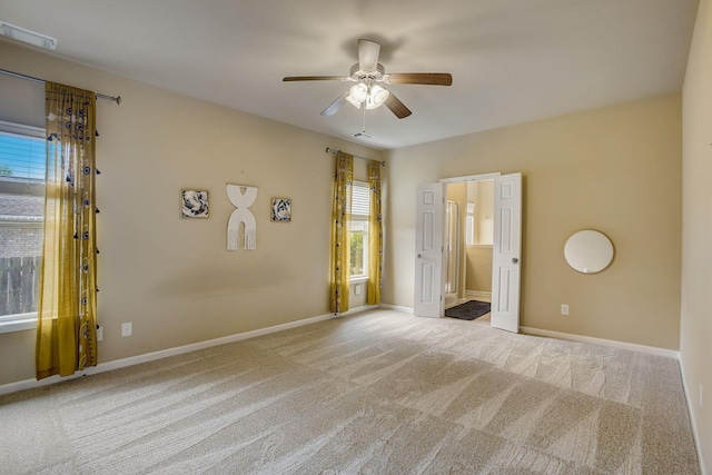 carpeted spare room with visible vents, ceiling fan, and baseboards