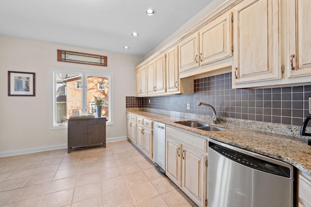 kitchen with tasteful backsplash, stainless steel dishwasher, a sink, light stone countertops, and baseboards