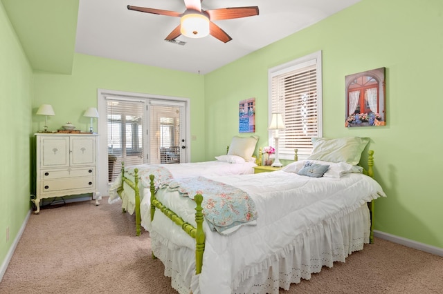 carpeted bedroom with access to outside, visible vents, ceiling fan, and baseboards