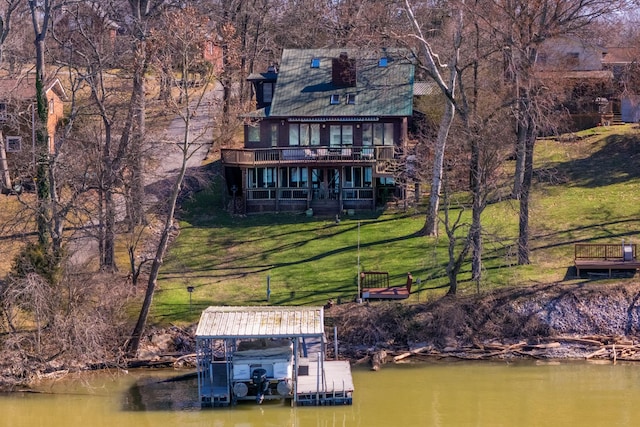 view of dock with a lawn and a water view