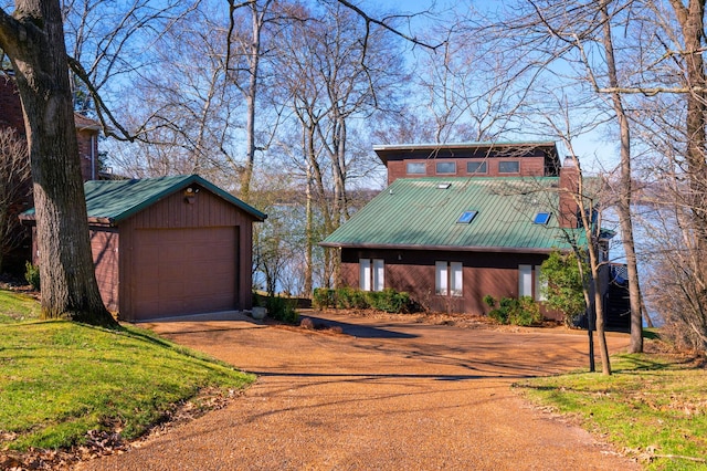 rustic home featuring a garage, metal roof, and driveway