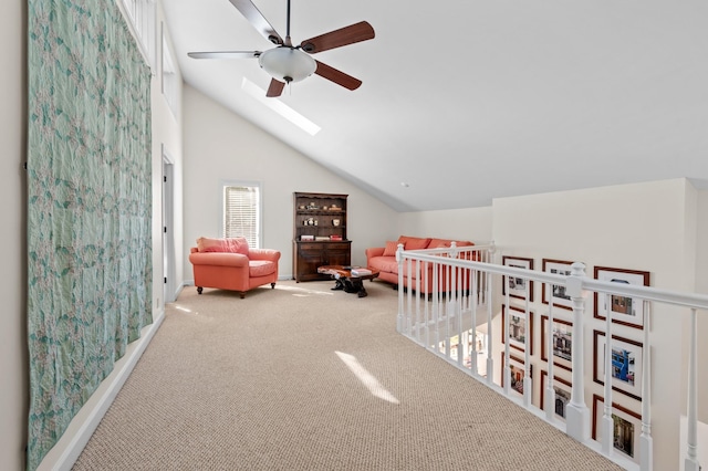 carpeted bedroom featuring ceiling fan, vaulted ceiling with skylight, and a crib