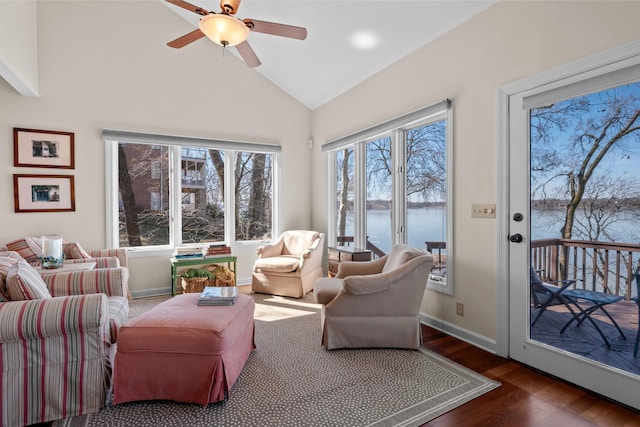 living area featuring lofted ceiling, a water view, ceiling fan, wood finished floors, and baseboards