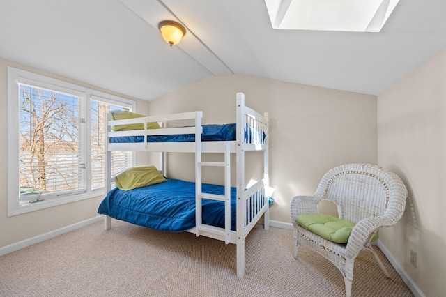 carpeted bedroom with vaulted ceiling with skylight and baseboards