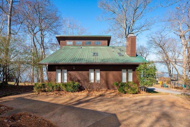 view of front of home with a chimney and metal roof