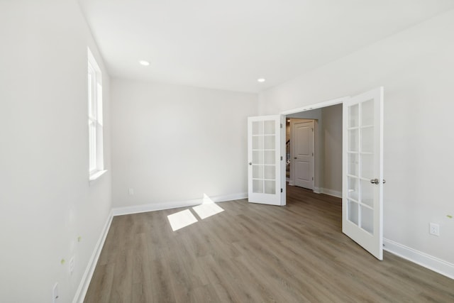 unfurnished bedroom with recessed lighting, french doors, baseboards, and wood finished floors