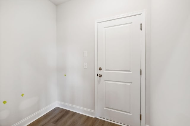 doorway with dark wood finished floors and baseboards