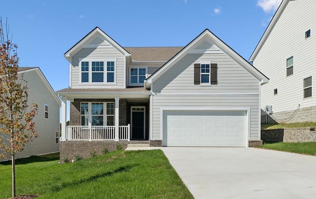 view of front of house featuring brick siding, covered porch, an attached garage, a front yard, and driveway