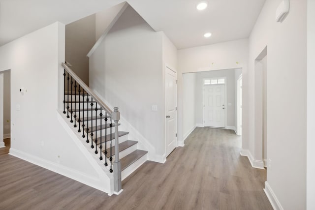 foyer featuring stairs, baseboards, wood finished floors, and recessed lighting