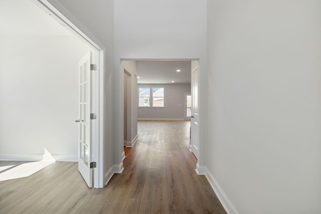 hall with baseboards, wood finished floors, and recessed lighting