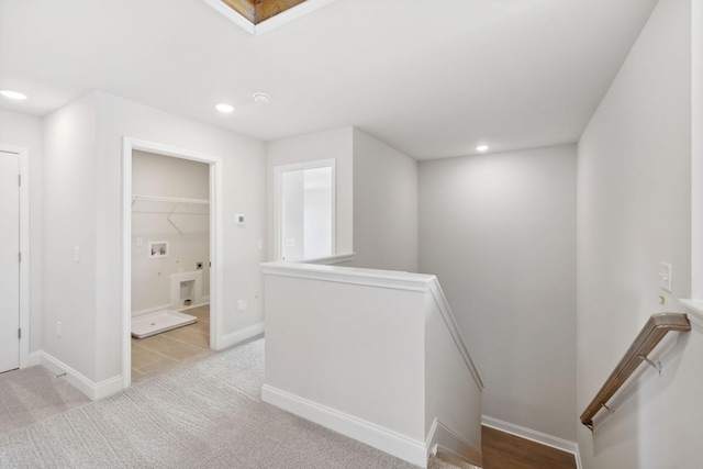 hall featuring recessed lighting, carpet, baseboards, and an upstairs landing