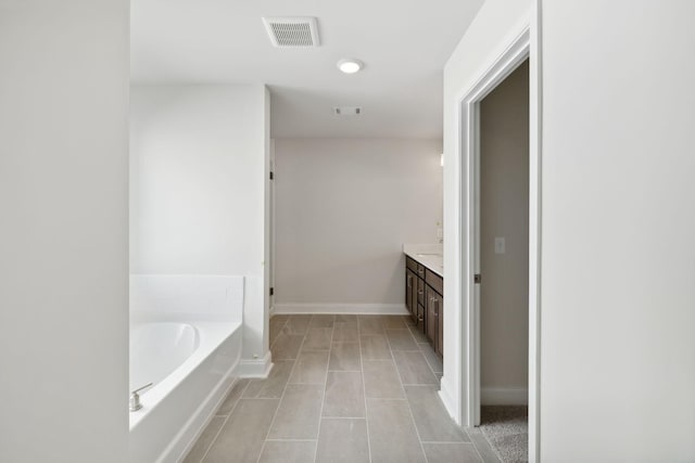 bathroom with a garden tub, visible vents, vanity, tile patterned flooring, and baseboards