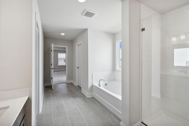 full bathroom with a garden tub, visible vents, tiled shower, and vanity