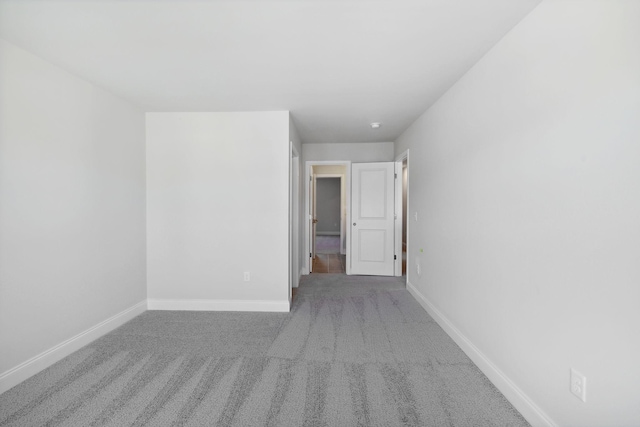 spare room featuring carpet and baseboards