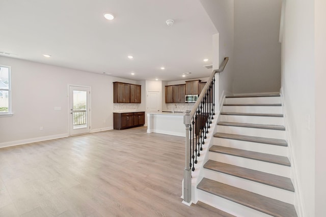 interior space with recessed lighting, visible vents, stairway, light wood-type flooring, and baseboards