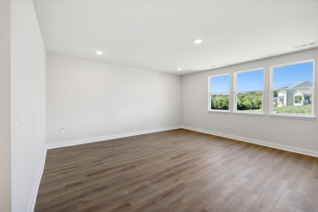 unfurnished room featuring recessed lighting, visible vents, baseboards, and wood finished floors