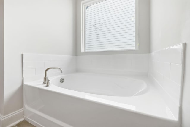 bathroom featuring a healthy amount of sunlight and a garden tub