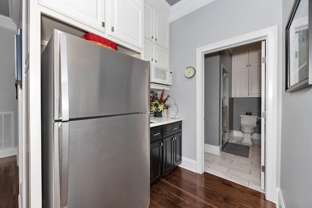 18543 Tillman Mill Rd, Athens, AL 35614 - kitchen featuring white cabinets, white microwave, dark wood-type flooring, freestanding refrigerator, and light countertops