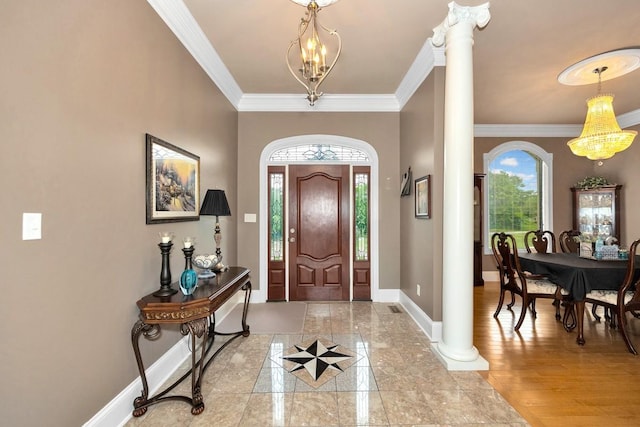 foyer with ornate columns, ornamental molding, a chandelier, light wood-type flooring, and baseboards