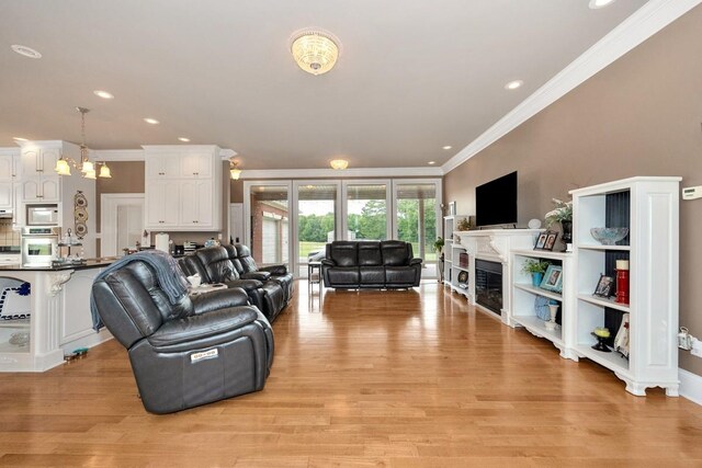 18707 Tillman Mill Rd, Athens, AL 35614 - living room featuring crown molding, a fireplace, recessed lighting, an inviting chandelier, and light wood-type flooring
