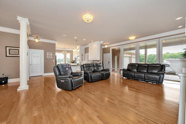 18707 Tillman Mill Rd, Athens, AL 35614 - living room with a chandelier, light wood-style flooring, baseboards, ornamental molding, and ornate columns
