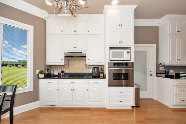 18707 Tillman Mill Rd, Athens, AL 35614 - kitchen featuring dark countertops, white microwave, under cabinet range hood, and oven