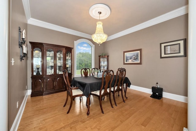 dining area featuring ornamental molding, light wood finished floors, and baseboards