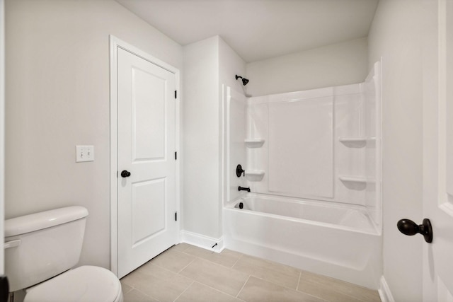 bathroom featuring bathing tub / shower combination, tile patterned flooring, toilet, and baseboards