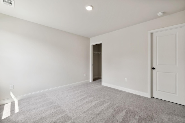 carpeted empty room featuring baseboards and visible vents