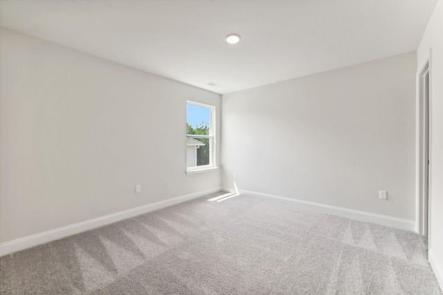 unfurnished room featuring carpet and baseboards