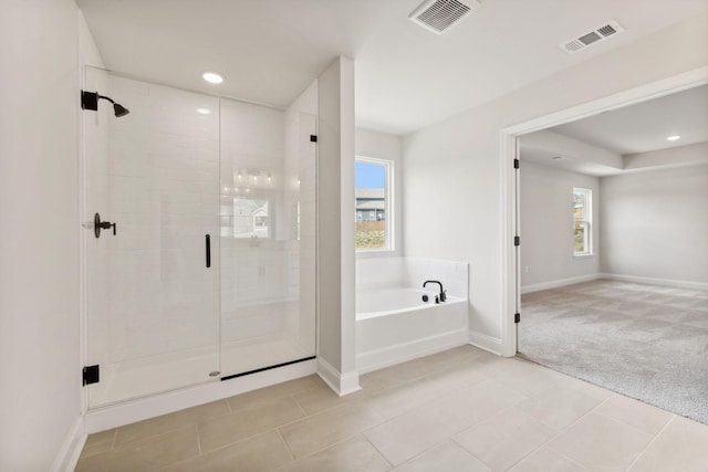 full bath featuring a garden tub, baseboards, visible vents, and a stall shower