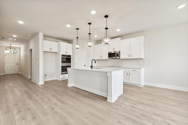 kitchen with white cabinetry, visible vents, appliances with stainless steel finishes, and a sink