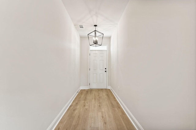 entryway with a chandelier, light wood-style flooring, visible vents, and baseboards