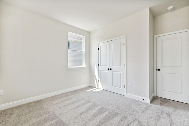 unfurnished bedroom featuring a closet, carpet, and baseboards