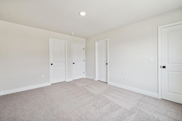 unfurnished bedroom with baseboards and light colored carpet