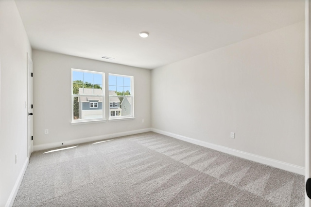 carpeted empty room featuring visible vents and baseboards